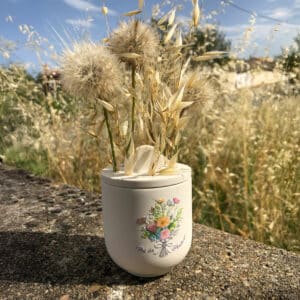 Pot de senteur en Jesmonite naturelle fait main, décoré d’une illustration de bouquet romantique aux tons pastel, avec fleurs séchées piquées dans le couvercle percé